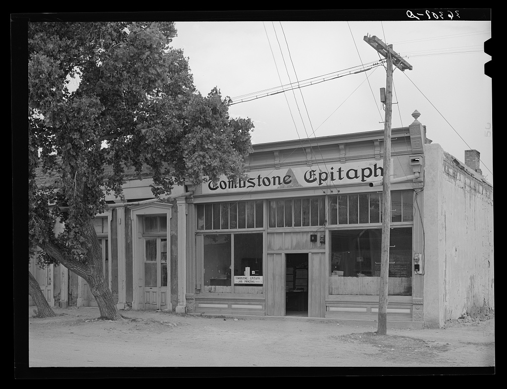Public domain photograph of a newspaper office with desks, papers, and editorial equipment.